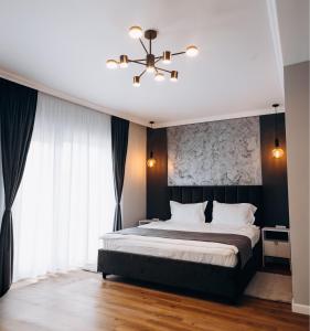a bedroom with a large bed and a chandelier at Pensiunea Brici Junior in Cluj-Napoca