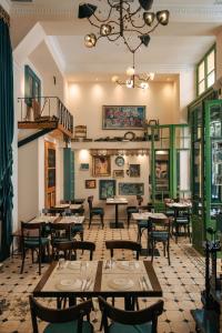 un restaurante con mesas y sillas y una lámpara de araña en Beautiful City Suites, en Atenas