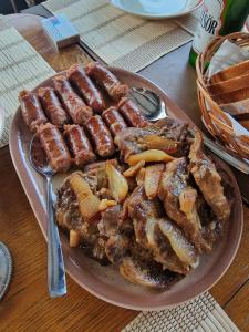 a plate of sausages and other food on a table at Flori Haus Saschiz in Saschiz