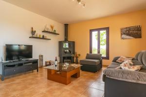 ein Wohnzimmer mit einem Sofa und einem TV in der Unterkunft Finca Son Puça in Petra