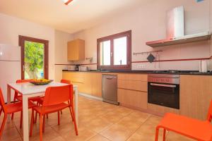 ペトラにあるFinca Son Puçaのキッチン(テーブル、赤い椅子、テーブル、テーブル付)