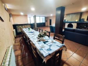 a long dining room table with chairs and a table cloth at La Pérgola in La Cabrera