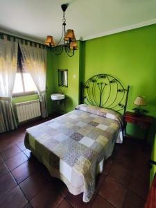 Schlafzimmer mit einem Bett mit grünen Wänden und einem Fenster in der Unterkunft La Pérgola in La Cabrera