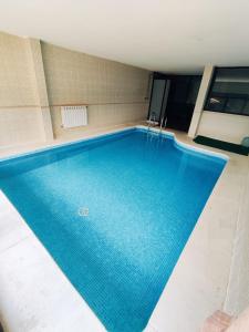 a swimming pool in a building with a large blue pool at La Pérgola in La Cabrera