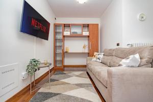 ein Wohnzimmer mit einem Sofa und einem TV in der Unterkunft Milan ARCIMBOLDI-Private Parking 20min dal DUOMO in Mailand