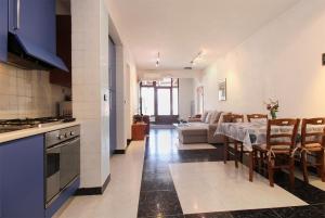 een keuken en een woonkamer met een tafel en een bank bij Apartment Pula 2281 in Pula
