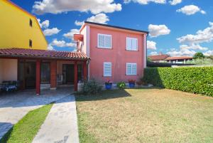 une maison rose avec une maison jaune dans l'établissement Apartment Pula 2281, à Pula