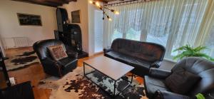 uma sala de estar com mobiliário de couro e uma mesa em Mott Residence em Tuzla