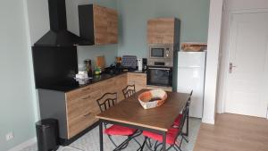 a kitchen with a wooden table with chairs and a dining room at Hendaye plage, Résidence Eskualduna A in Hendaye