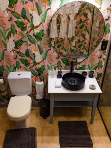 ein Badezimmer mit einem WC, einem Waschbecken und einem Spiegel in der Unterkunft Kidoti Villas by Z in Kidoti