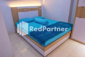 Una cama en una habitación con un cartel rojo de pareja. en Hotel Rai's Palopo Exclusive Mitra RedDoorz, en Palopo