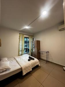 Schlafzimmer mit einem Bett und einem Fenster in der Unterkunft 3BR Near KKIA Homestay Cyber City Apartment in Kota Kinabalu