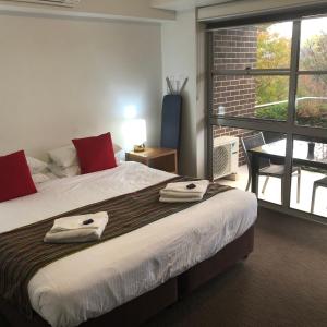 a bedroom with a large bed with towels on it at Charlestown Terrace Apartments in Newcastle