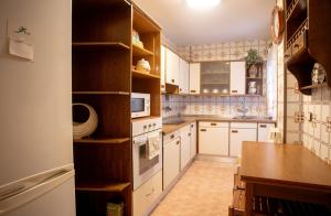 una cocina con armarios blancos y una mesa. en Apartamento Venecia en Unquera