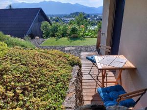 una terraza de madera con mesa y sillas en una casa en Wohnung *AusZeit* en Weiler