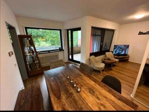 ein Wohnzimmer mit einem großen Holztisch und Stühlen in der Unterkunft Zu Hause in Bielefeld in Bielefeld