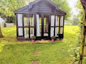 een kleine kas in een tuin met twee potplanten bij Stunning barn conversion ideal for large families in Bildeston