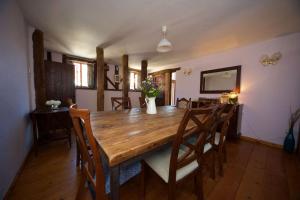 een eetkamer met een houten tafel en stoelen bij Stunning barn conversion ideal for large families in Bildeston