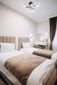 1 dormitorio con 2 camas y escritorio en Pensiunea Brici Junior en Cluj-Napoca