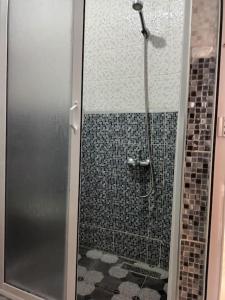 a shower with a glass door in a bathroom at appartement de nouri à marti in Martil