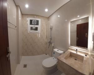 a bathroom with a toilet and a sink and a mirror at Al Sabeel Building in Salalah +9 photos