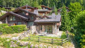 a house on a hill with a fence in front of it at Chalet Panorama in Chamonix-Mont-Blanc