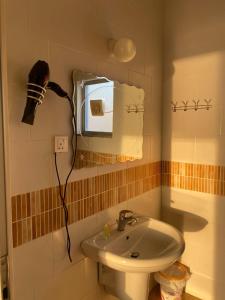 baño con lavabo y espejo en la pared en Aqaba Adventure Divers Resort & Dive Center, en Áqaba