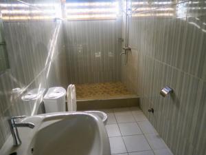 a bathroom with a shower with a sink and a toilet at Home Sweet Home Heritage Inn in Accra