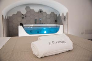 a towel sitting on a bed with a bath tub at Il Cocchiere in Palagianello