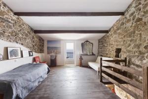 a bedroom with a bed and a stone wall at Schiara in Campiglia