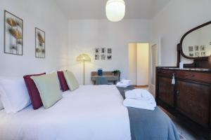 um quarto com uma cama branca, uma cómoda e um espelho. em Sweet Inn - Modigliani em Milão
