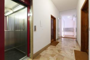 um corredor vazio com uma porta de vidro e um corredor gthngthngth em Sweet Inn - Modigliani em Milão
