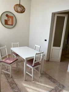 a white table and chairs in a room at A 2 passi dal mare II - grazioso trilocale a Locri in Locri +11 photos