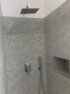 y baño con ducha y pared de piedra. en DomusEli, en Santa Maria di Castellabate