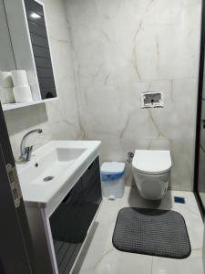 uma casa de banho branca com um lavatório e um WC em Sahil dairesi em Atakum