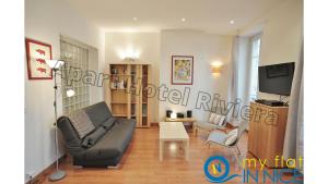 a living room with a couch and a tv at ApartHotel Riviera - Liberte 1 - Grimaldi Promenade des Anglais 5mn - Supérieur 2 chambres AC - Emplacement Exceptionnel in Nice