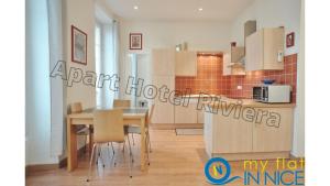 a kitchen and dining room with a table and chairs at ApartHotel Riviera - Liberte 1 - Grimaldi Promenade des Anglais 5mn - Supérieur 2 chambres AC - Emplacement Exceptionnel in Nice +6 photos