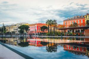 een stad met een reflectie van gebouwen in het water bij ApartHotel Riviera - Grimaldi Promenade des Anglais 5mn - Supérieur 3 pièces AC - Emplacement Exceptionnel - LIBERTE 1 in Nice
