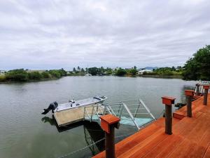 a boat is docked at a dock on a lake at Master Bedroom in Shared Cozy River View Pool Apartment in Nadi