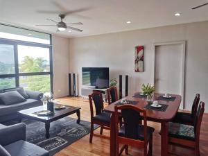 uma sala de estar com uma mesa e uma sala de jantar em Master Bedroom in Shared Cozy River View Pool Apartment em Nadi