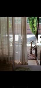 widok na okno z zasłonami i krzesłem w obiekcie Lake apartments w mieście Struga