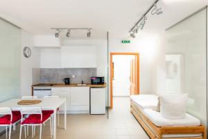 Il comprend une cuisine et un salon avec une table et des chaises. dans l'établissement Apartmán Muzeum obchodu, à Karlštejn