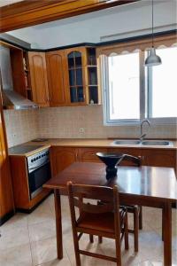 cocina con mesa de madera y silla de madera en Bebas apartment in the centre, en Sarandë