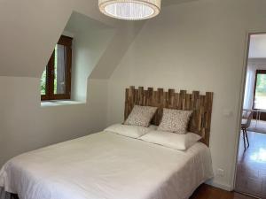 - une chambre avec un grand lit blanc et 2 oreillers dans l'établissement La Grangette, à Béduer
