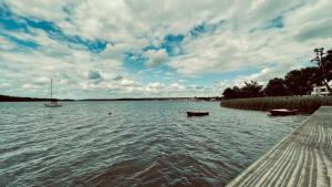two boats sitting on the water near a dock at Hotel Bellevue in Charzykowy
