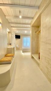 una grande stanza con pareti bianche e una grande finestra di Moustakas Beach Apartments ad Adámas