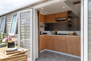 a kitchen with wooden cabinets and a table with flowers at Beachside Vakantiepark in Blankenberge