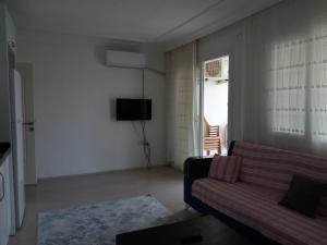 a living room with a couch and a television at Demir Apart Otel in Kaş