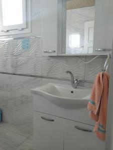 a white bathroom with a sink and a mirror at Demir Apart Otel in Kaş +158 photos