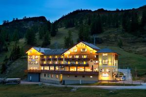 een groot gebouw op een heuvel 's nachts bij Hotel Hierzegger in Tauplitzalm